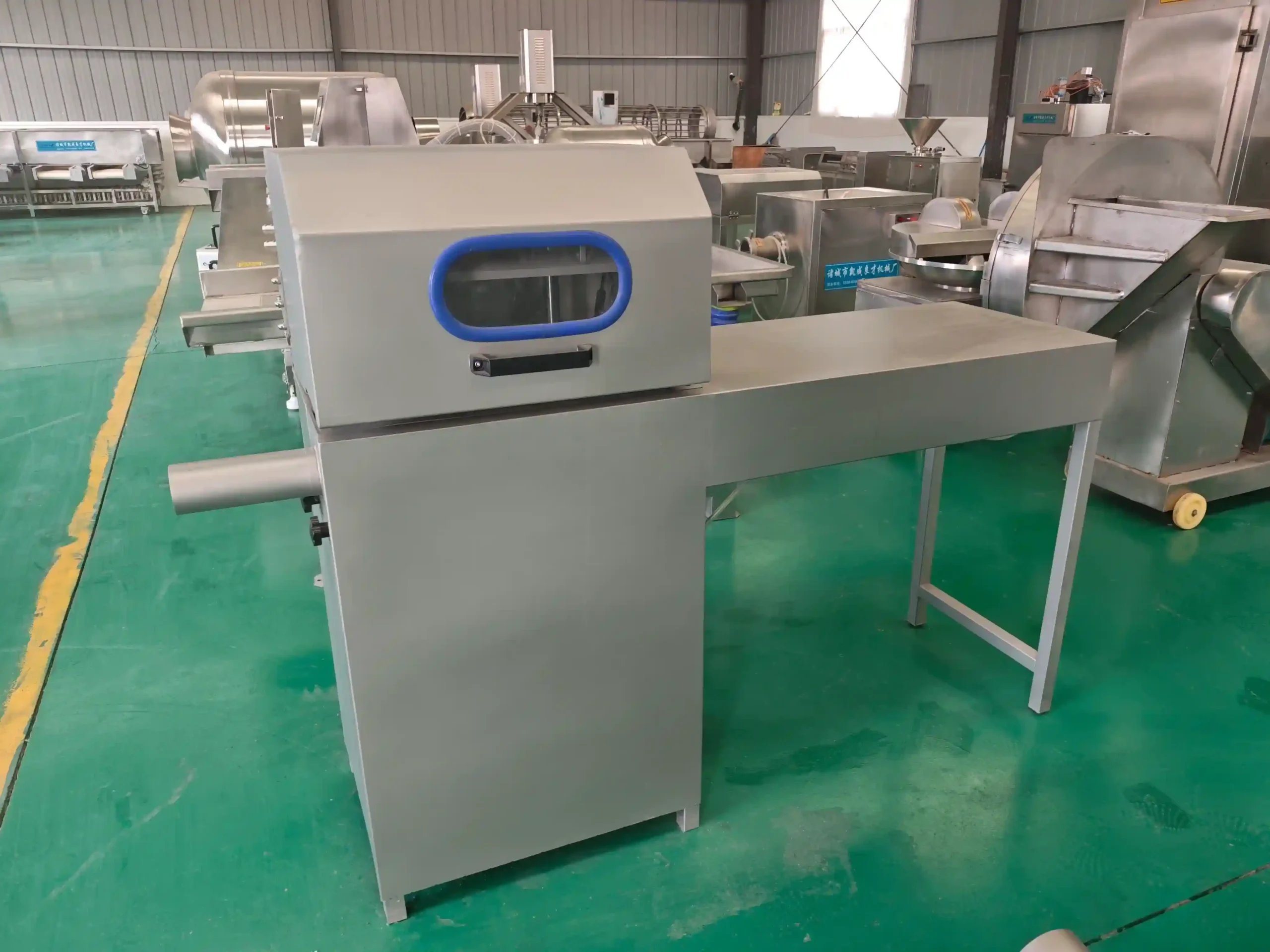 Stainless steel mutton roll stuffer machine equipped with an extended operating table.